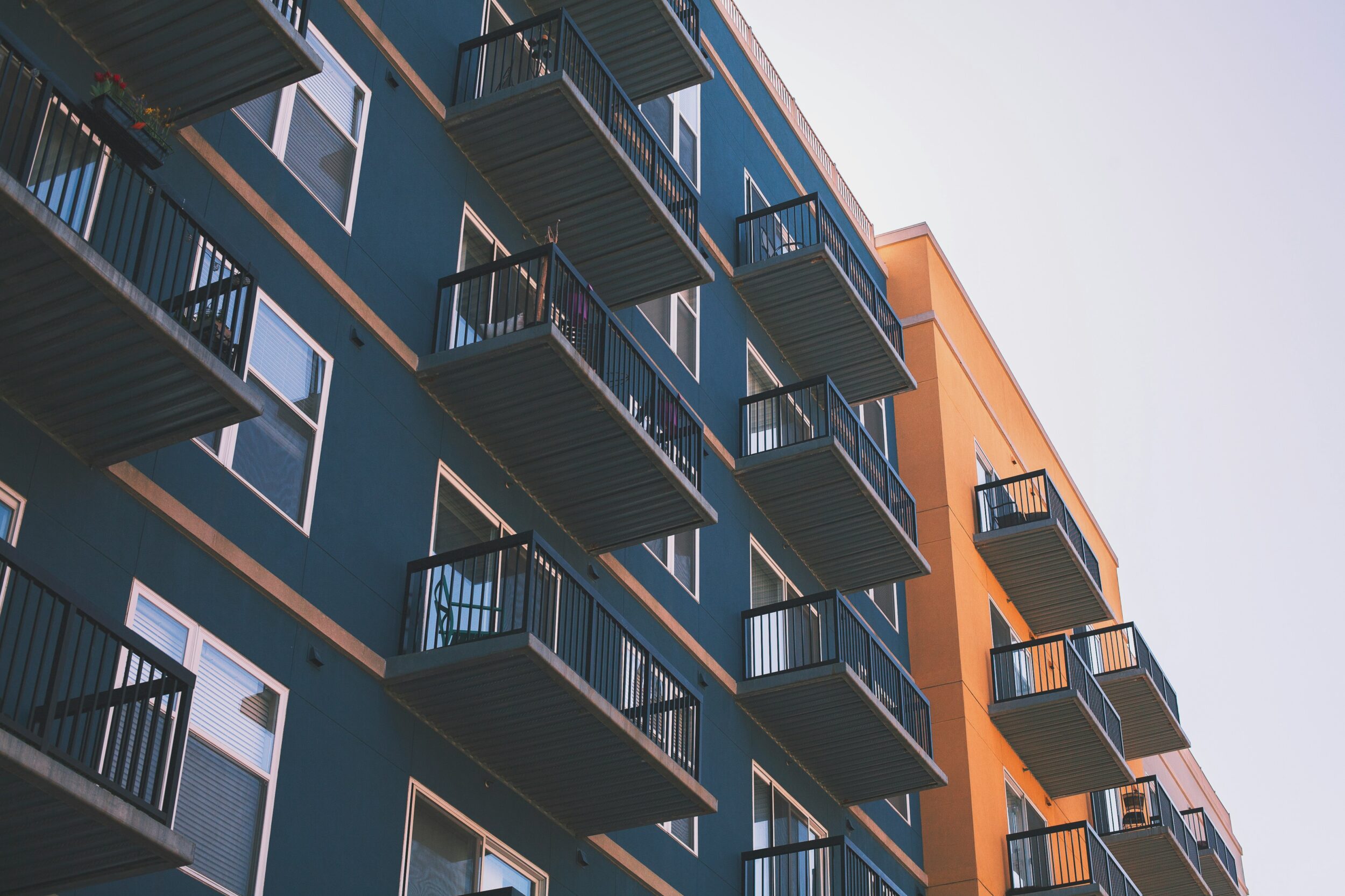 Exterior shot of an apartment complex, showing multiple balconies. Image credit Brandon Griggs on Unsplash.