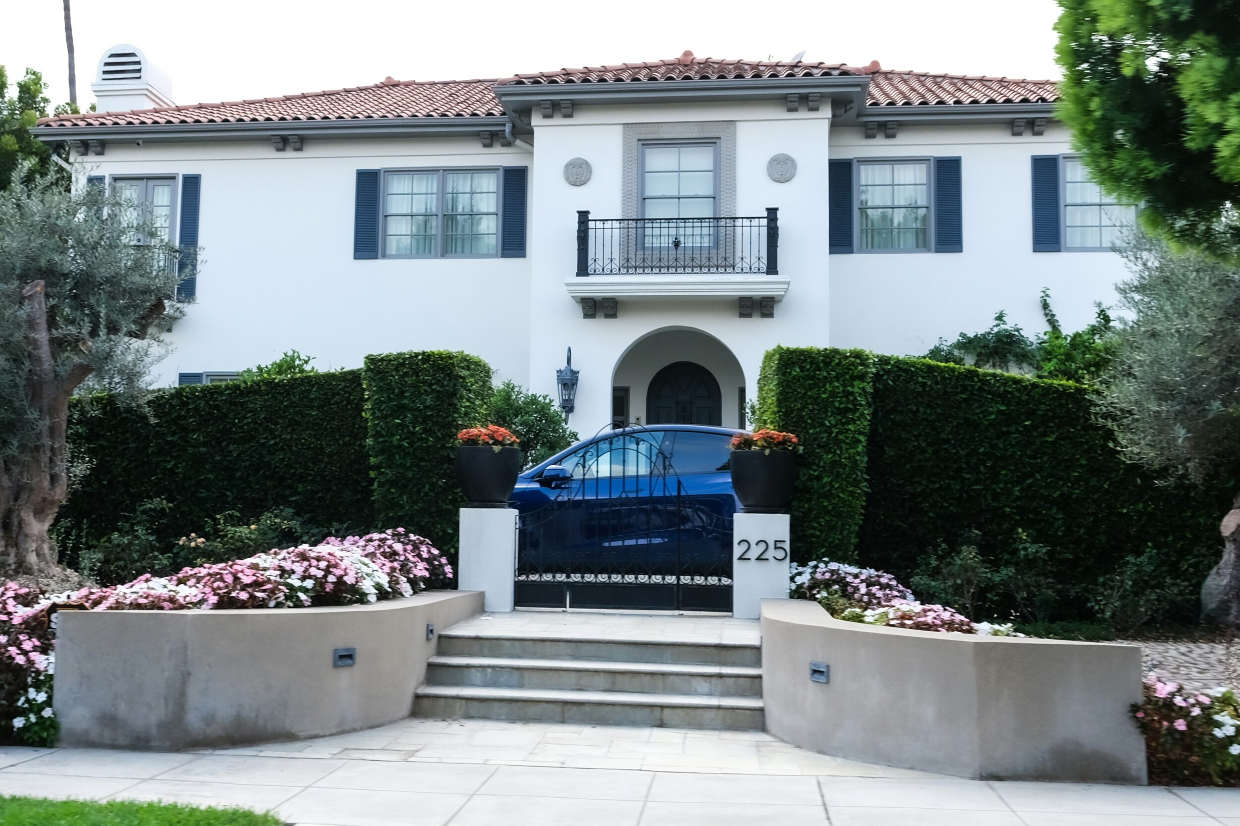 Exterior shot of a Mediterranean style home featuring a terracotta roof and white stucco siding. Image credit ubeyonroad on Unsplash.