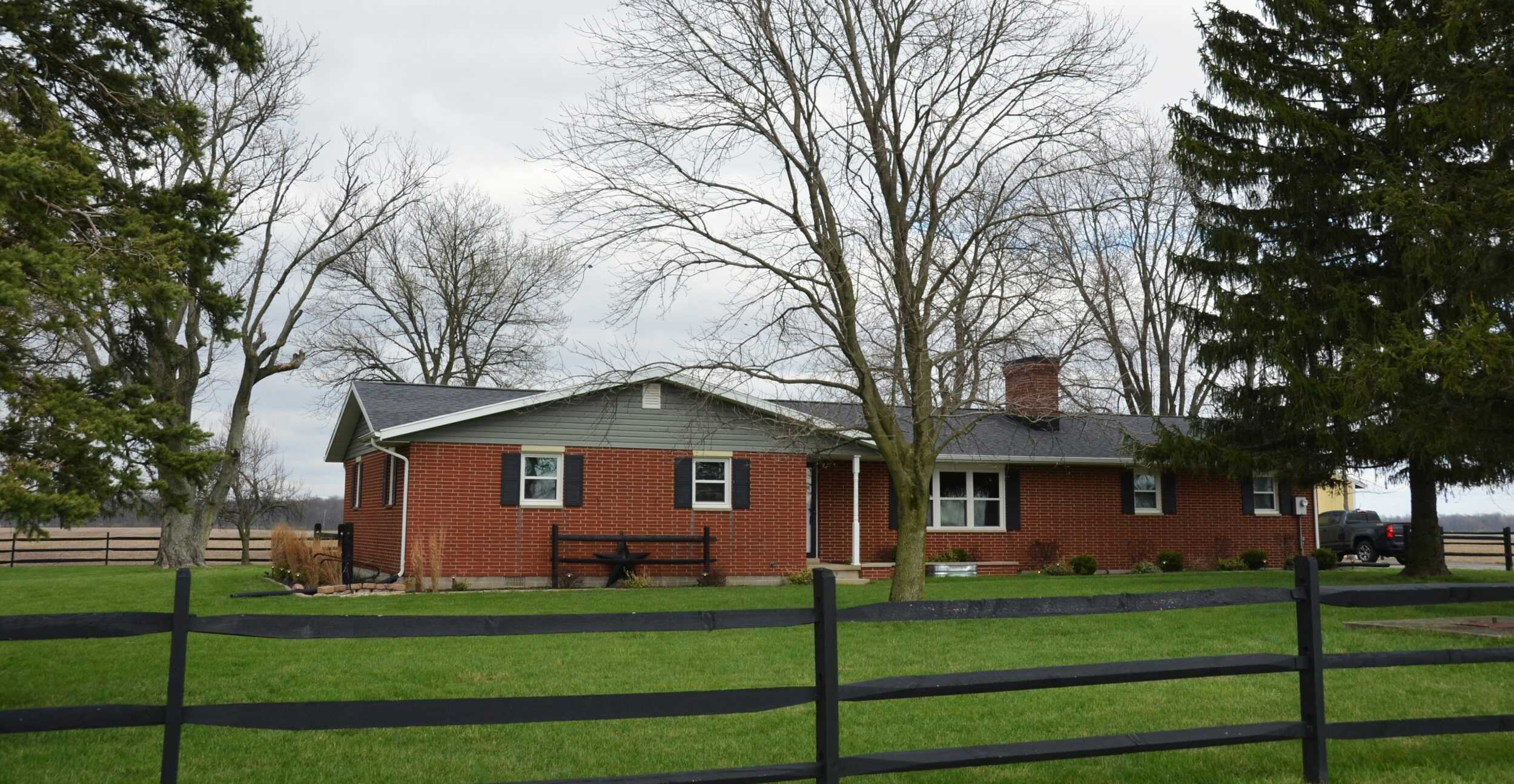 An image of a ranch-style home featuring a low roof and brick construction. Image credit Roger Starnes Sr on Unsplash.