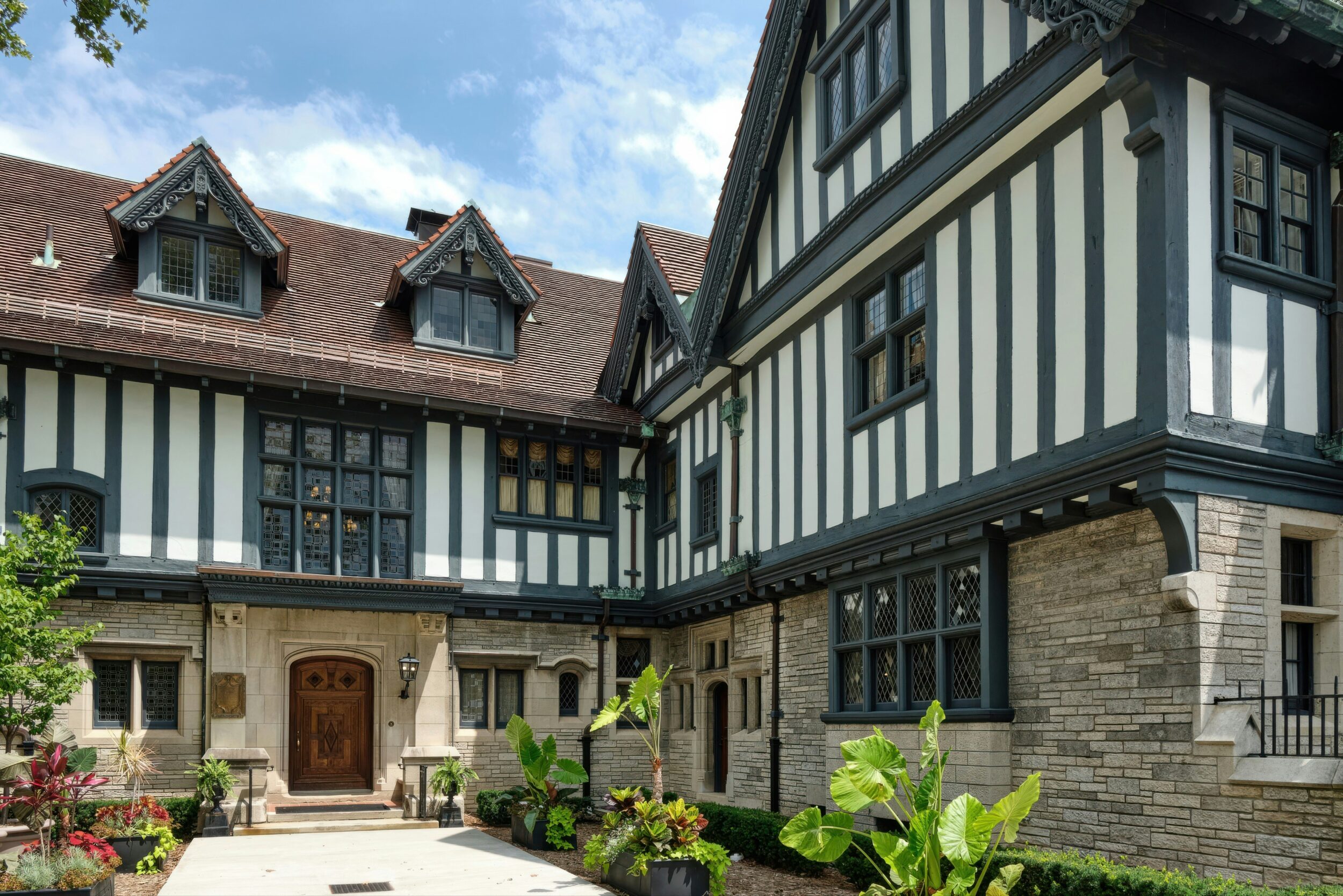 Exterior shot of a Tudor-style home featuring stone and stucco. Image credit Howard Walsh on Unsplash.